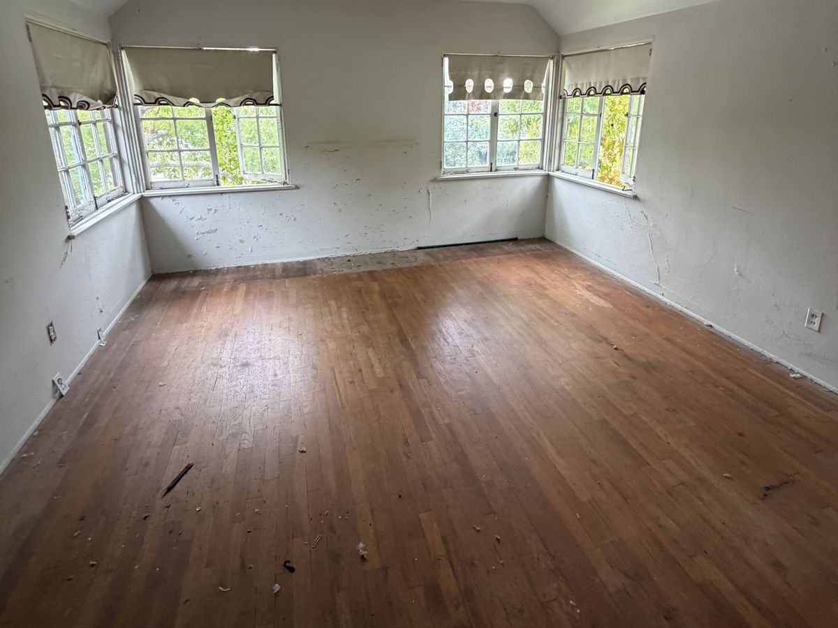 The same room emptied to bare hardwood floor, after