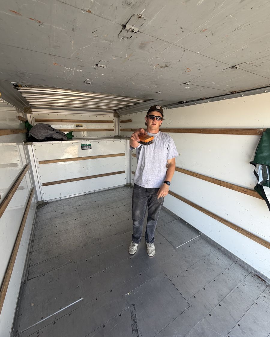 Crew member standing in the swept-out empty truck after a job