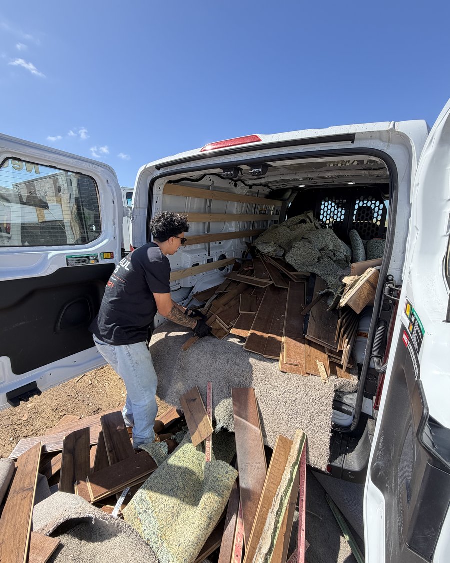 A Haul Boys crew member unloading flooring, carpet and pad from a cargo van for a San Diego County transfer station run